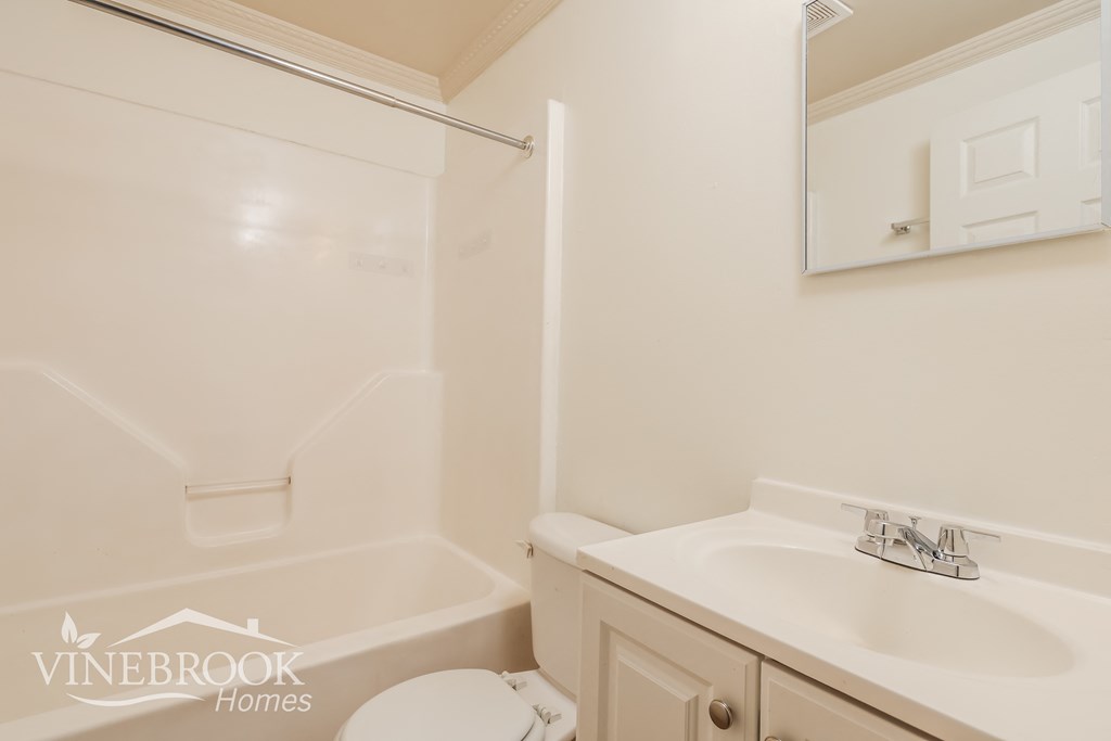 a white bathroom with a sink and a bath tub