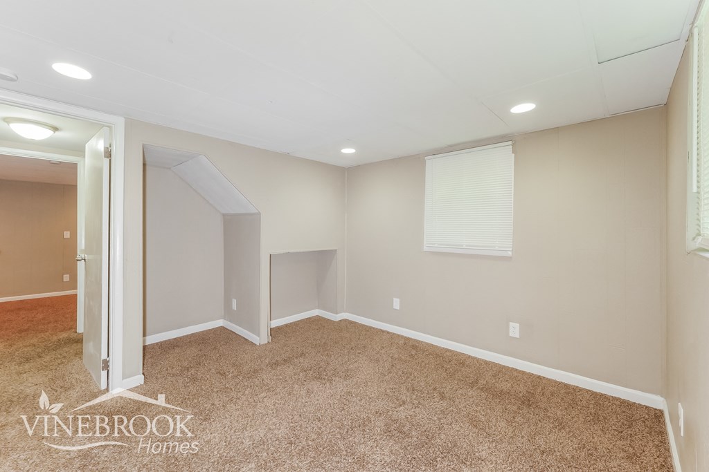 a bedroom with a carpeted floor and a door to a closet