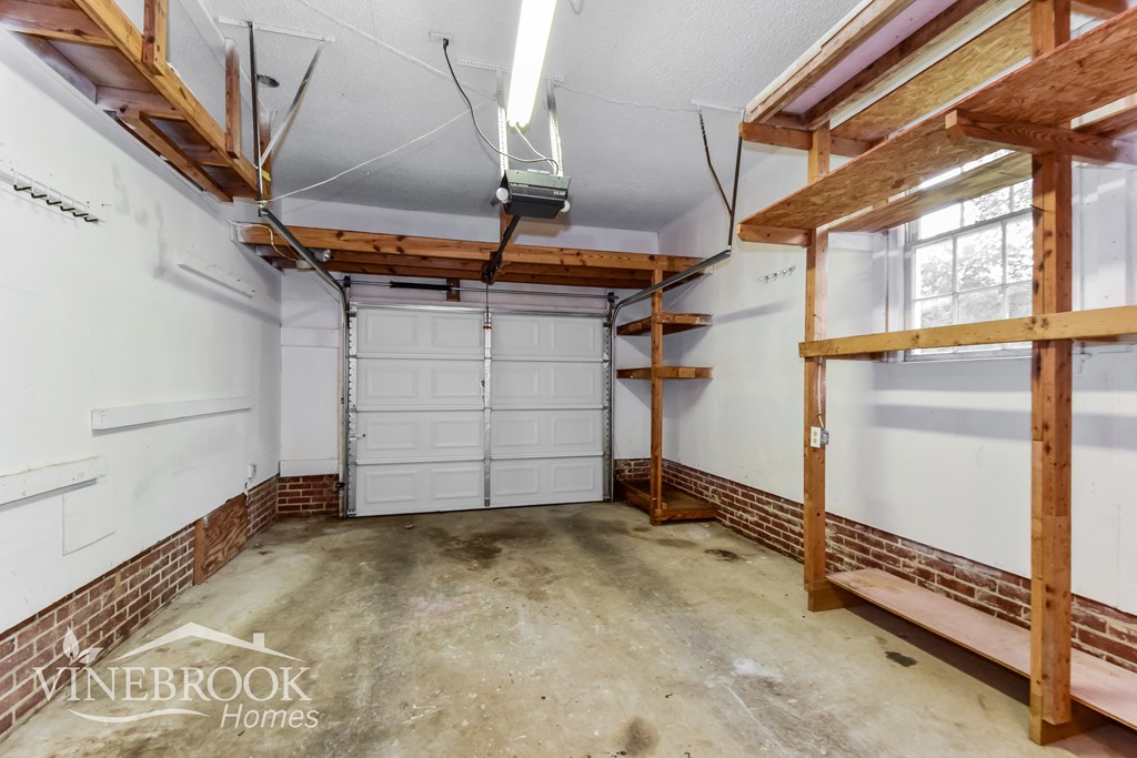 a garage with two white garage doors and a concrete floor