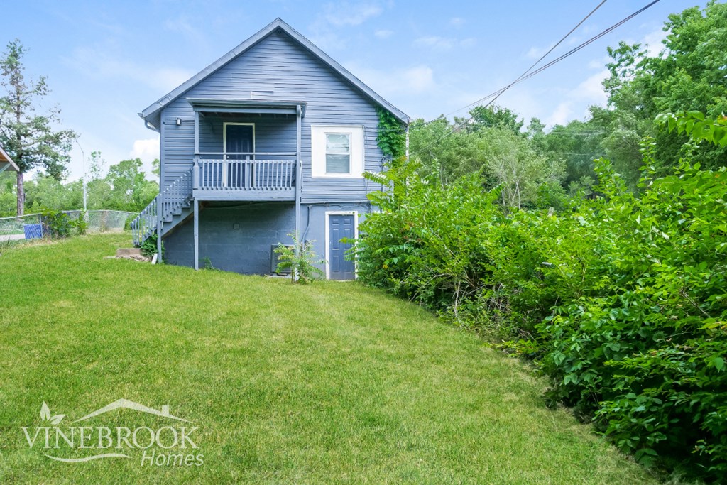 a blue house with a lawn in front of it
