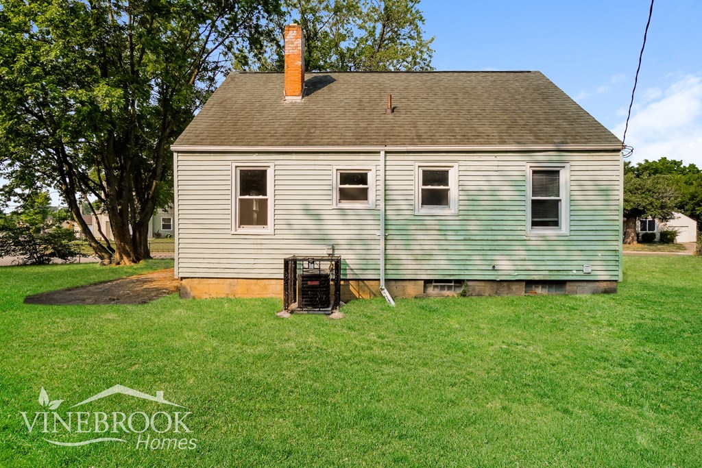 a backyard with a white house and a chicken coop