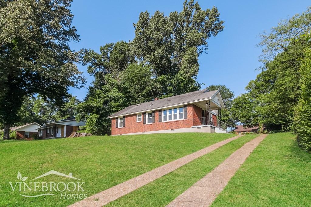 a home sits on the top of a grassy hill