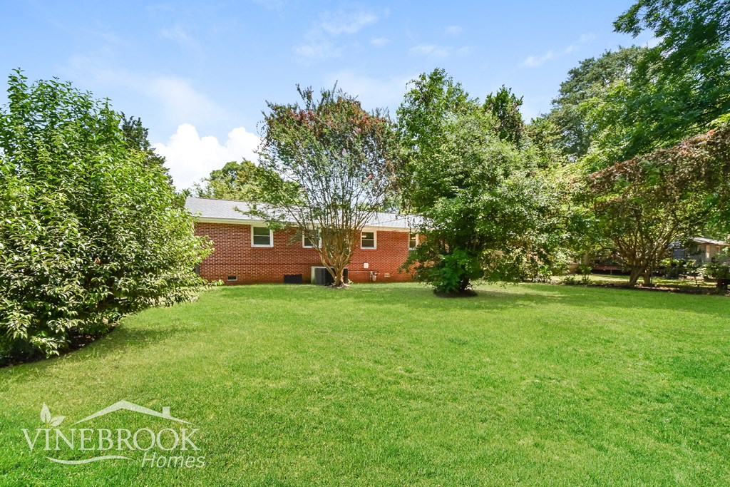 a large lawn in front of a brick house