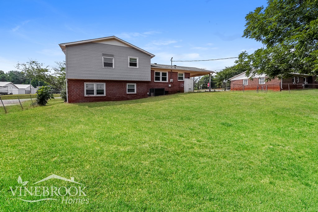 a backyard with a house and a grassy yard
