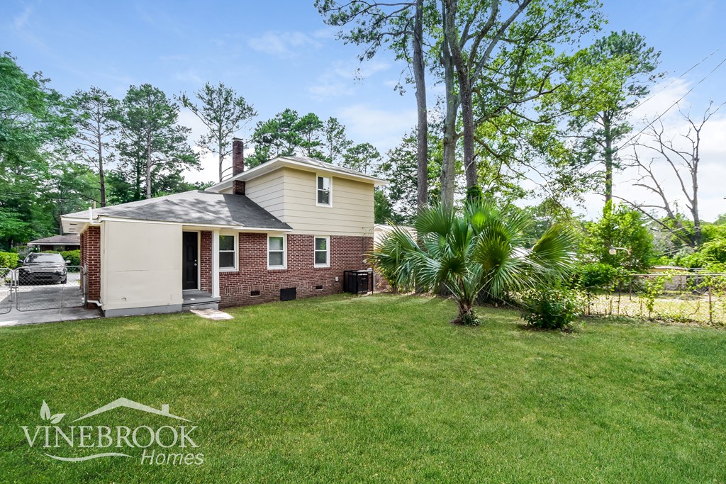 a backyard with a house and a palm tree