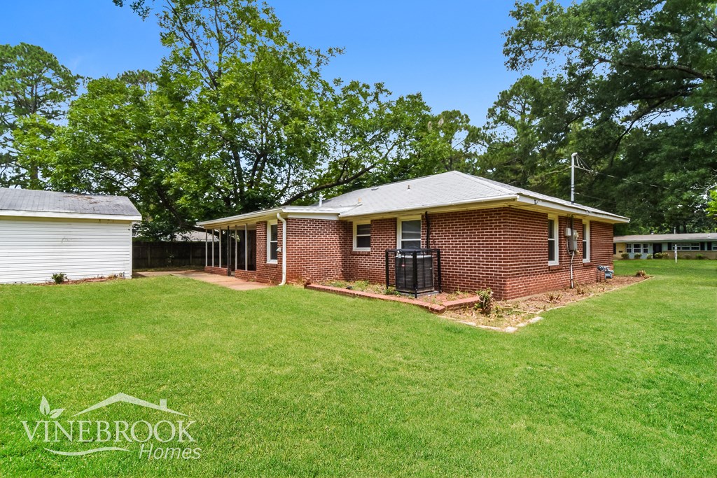a small brick house with a yard and a garage