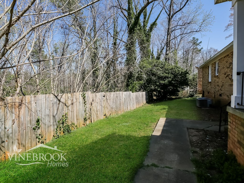 A backyard with a fence and a tree.