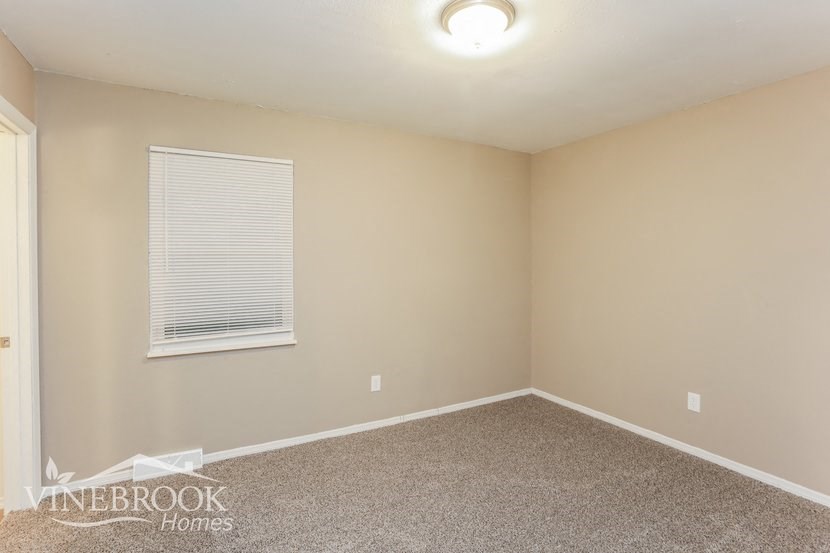 an empty room with a window and a carpet
