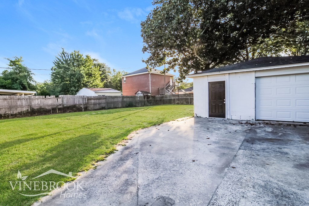 a backyard with a white garage and a fence