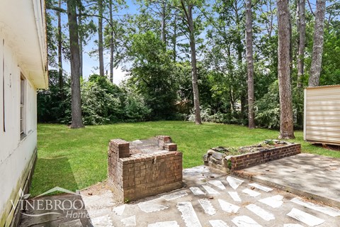 a backyard with a patio and a yard with trees