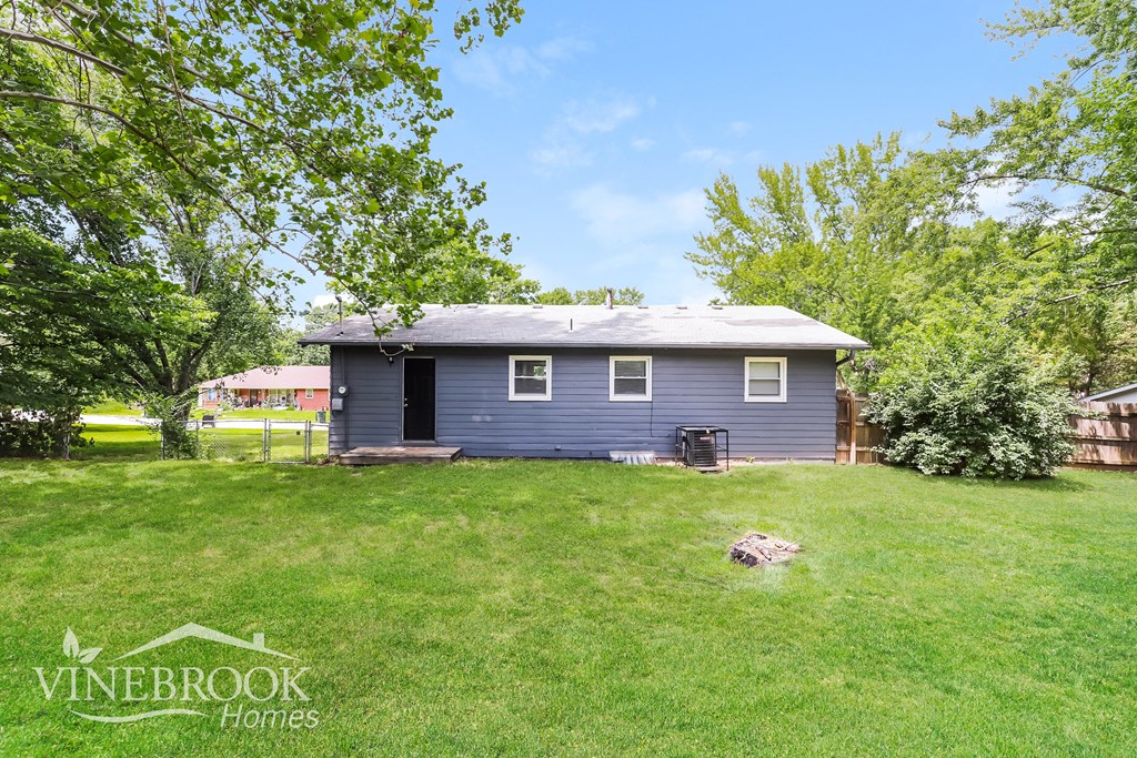 a small blue house in the middle of a grassy yard
