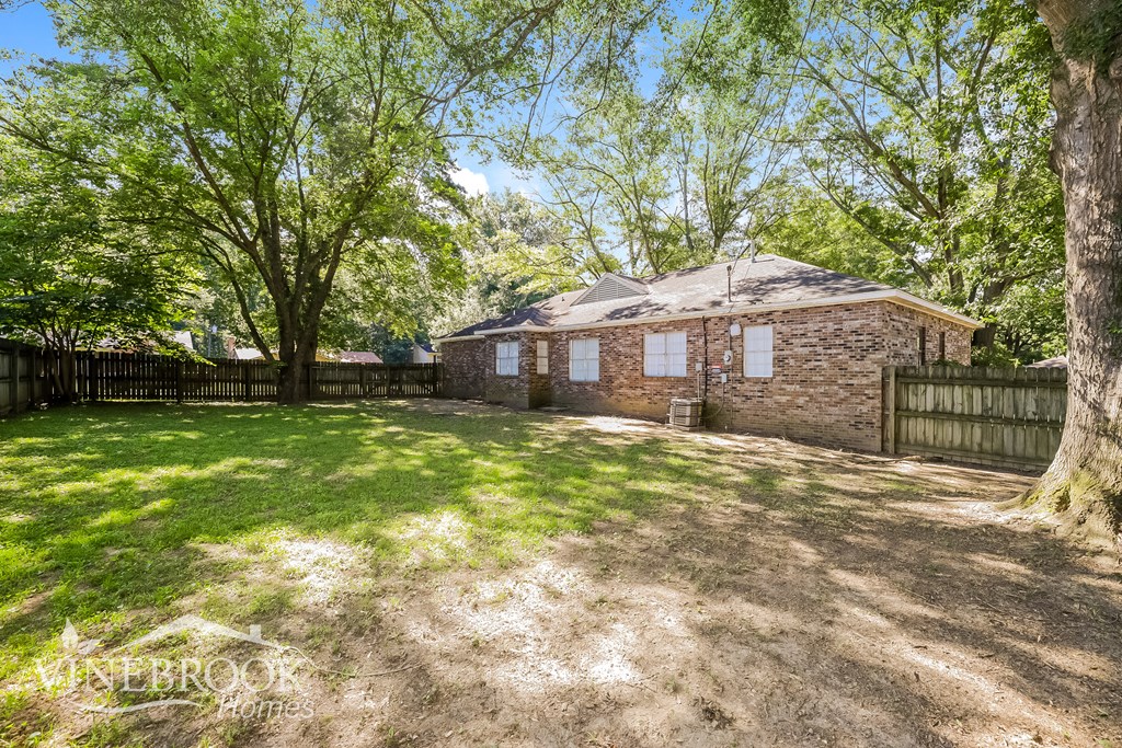 a brick house with a yard and a fence