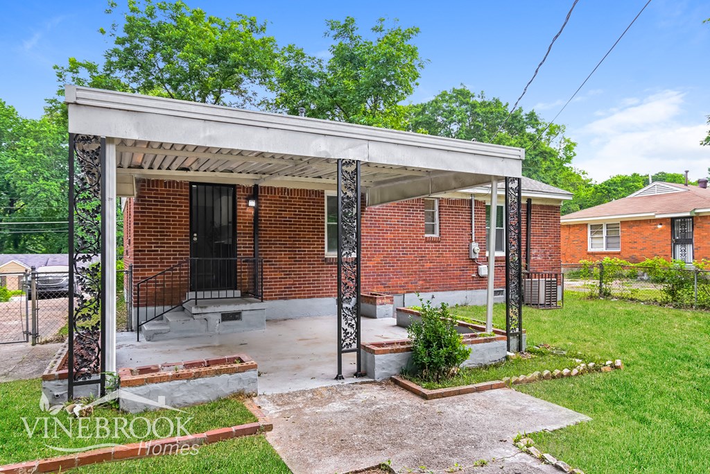 a small brick house with a covered porch and a porch swing