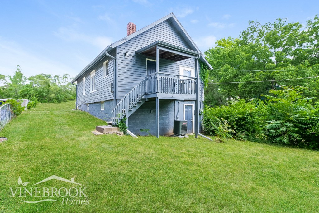 a blue house with a porch and a grassy yard