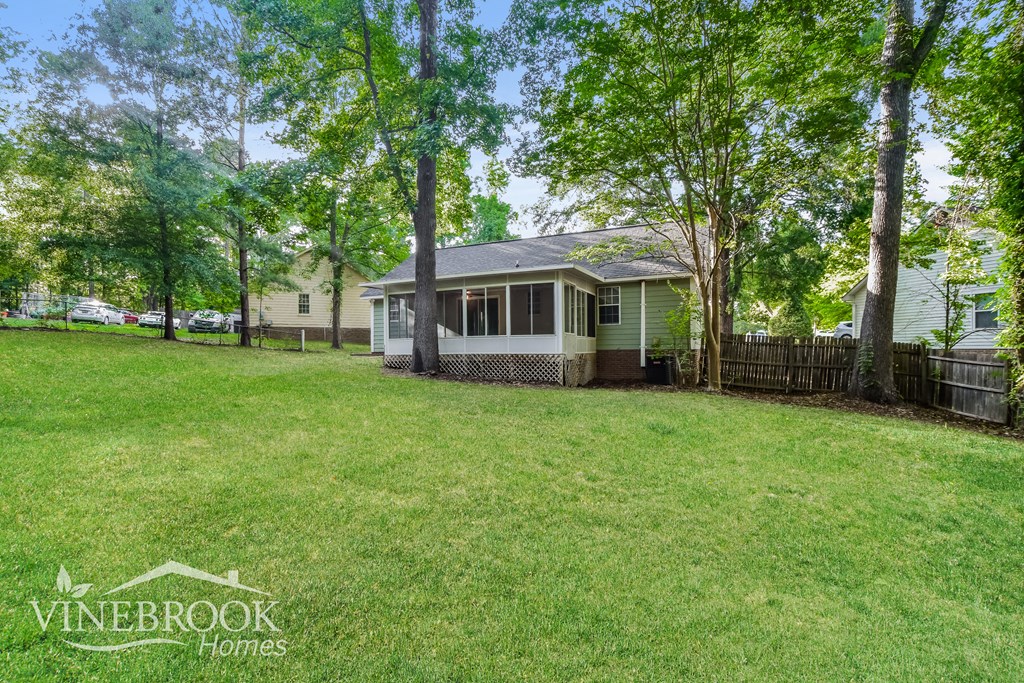 a backyard with a house and a yard with trees and a fence