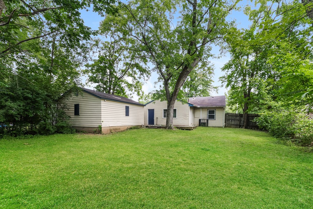 a white house with a yard and trees