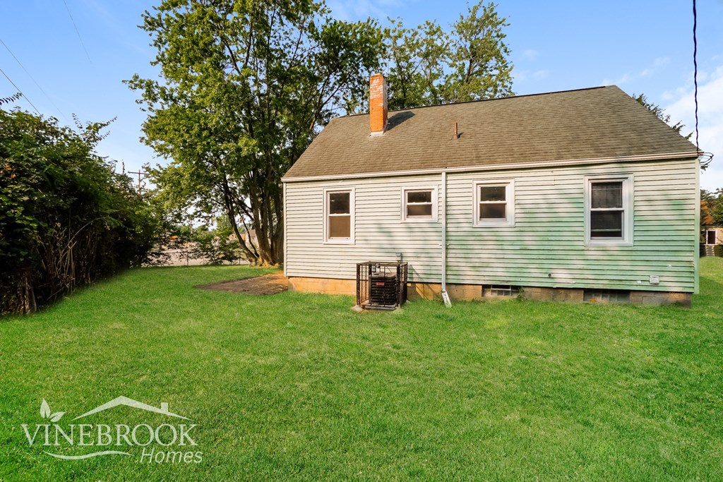 a backyard with a white house and a chicken coop