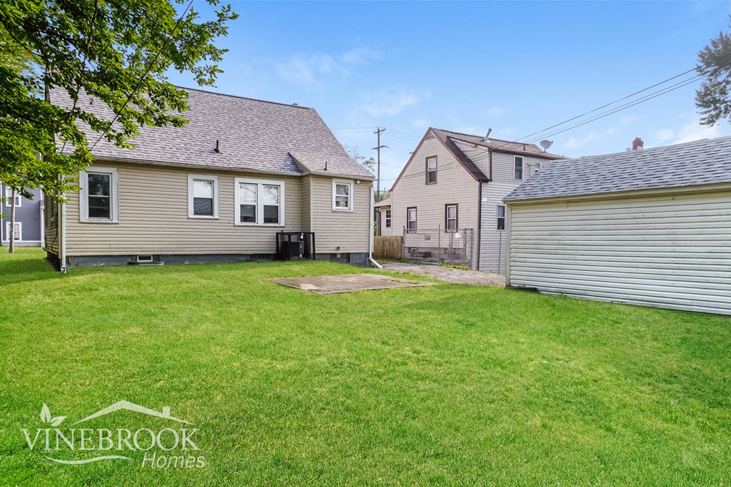 a backyard with two houses and a yard