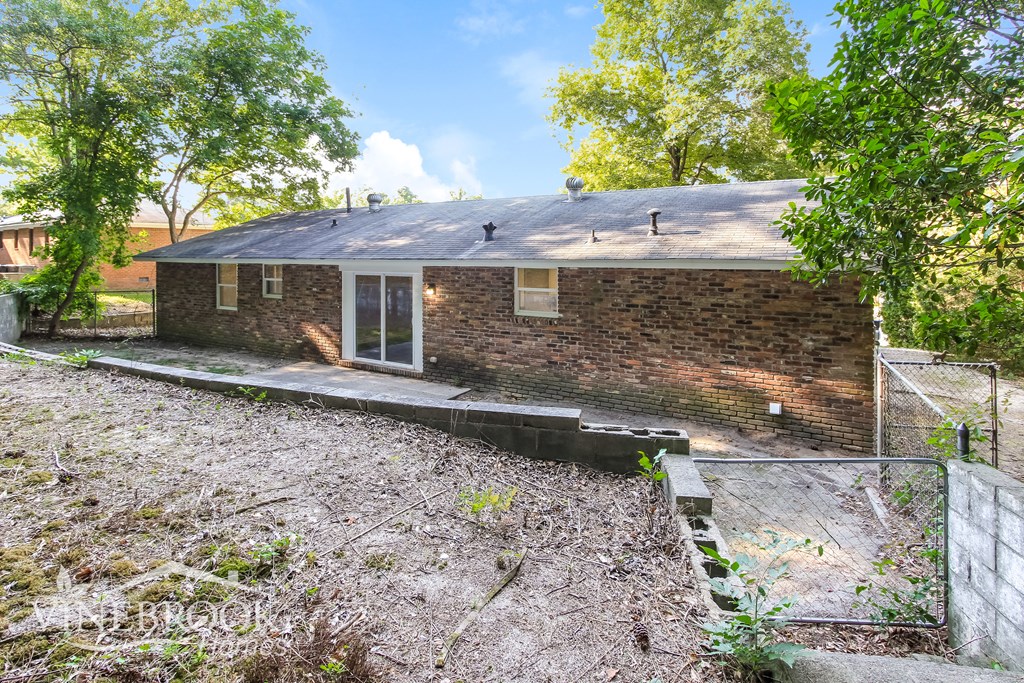 a brick house with a yard and a chain link fence