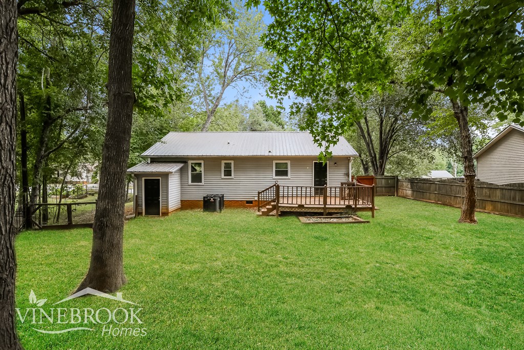 a small white house with a backyard and a deck