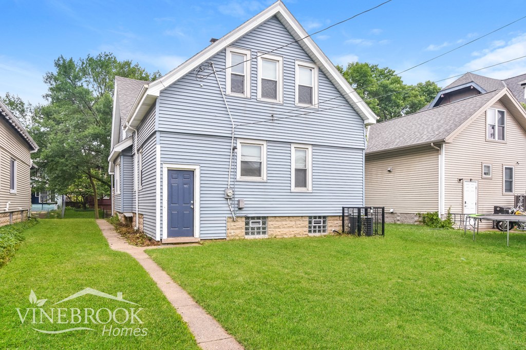 a blue house with a yard in front of it