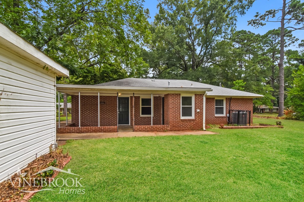 a small brick house with a yard and a garage