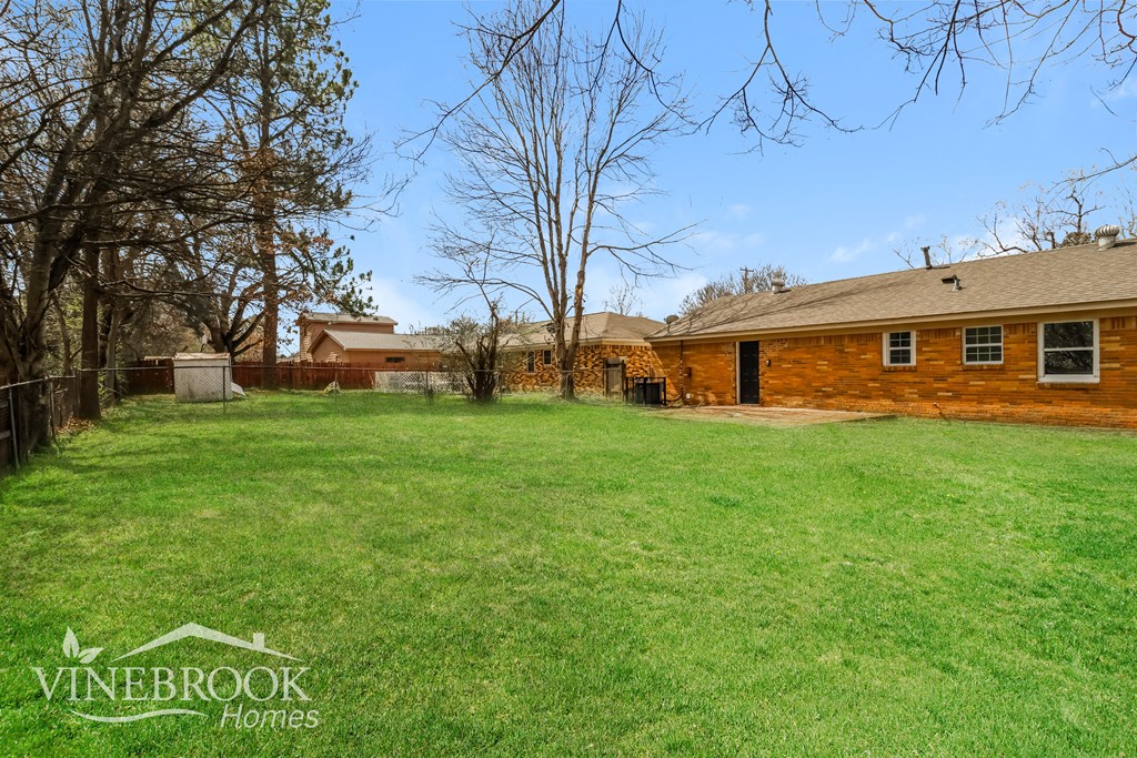 A Vinebrook Honeys property with a large grassy yard and a house in the background.