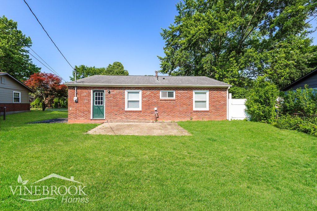 A brick house with a green door is for sale.
