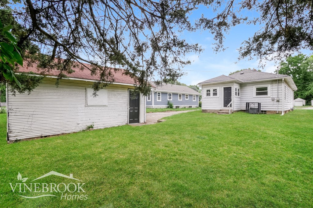 A Vinebrook Homes sign is on a grassy area in front of a house.