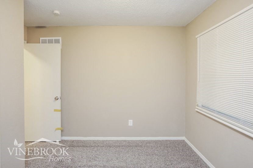 a empty room with a large window and a door