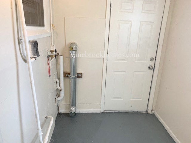 a small room with a door and a water pipe