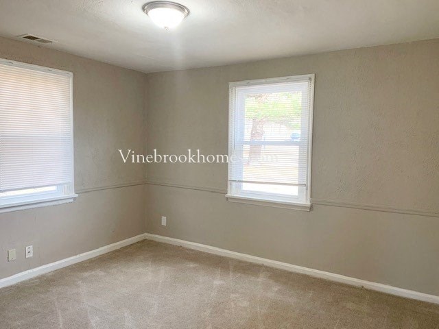 a large empty room with two windows in it