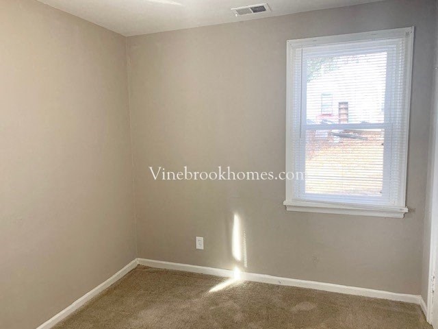 a small room with a window and a carpet