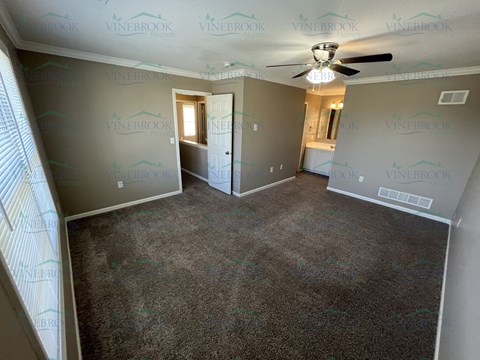 a living room with carpet and a ceiling fan