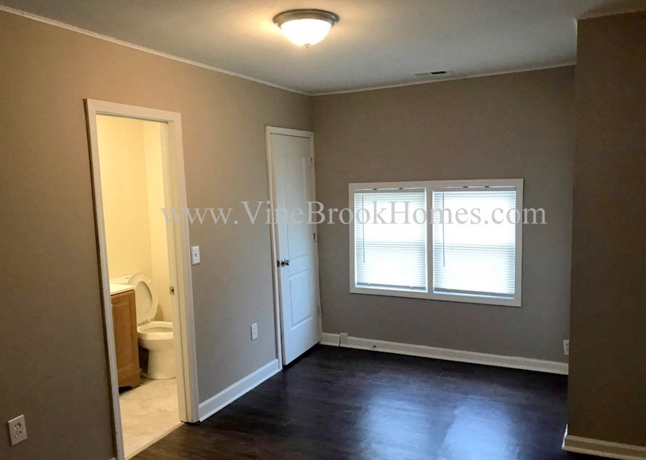 an empty living room with a toilet and a window