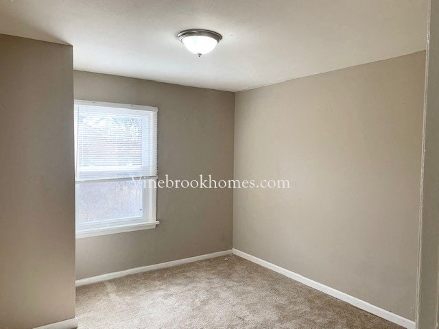 an empty empty room with a window and a ceiling light