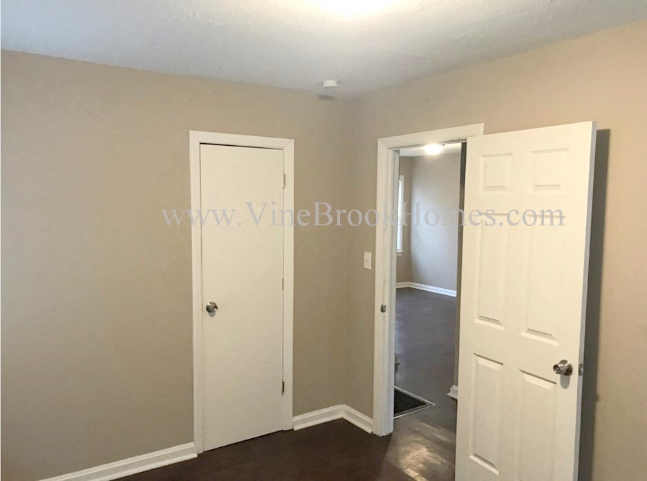 a small hallway with two doors and a closet