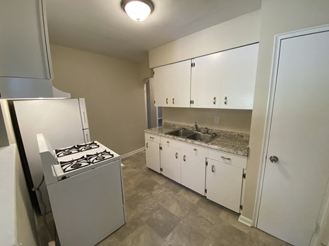 a kitchen with white cabinets and a stove and a sink