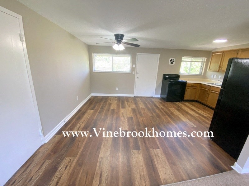 a kitchen and a living room with wood floors