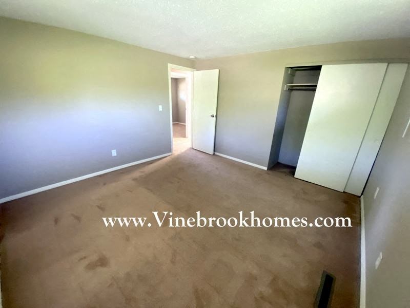 an empty living room with the closet doors open