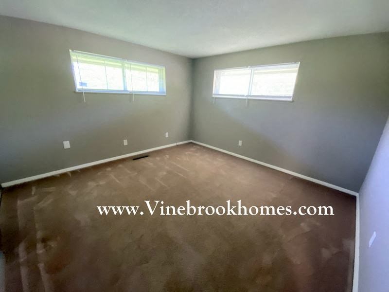 a empty room with concrete floor and two windows