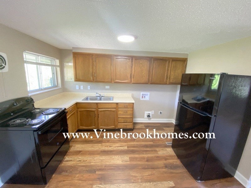 a kitchen with black appliances and wooden cabinets
