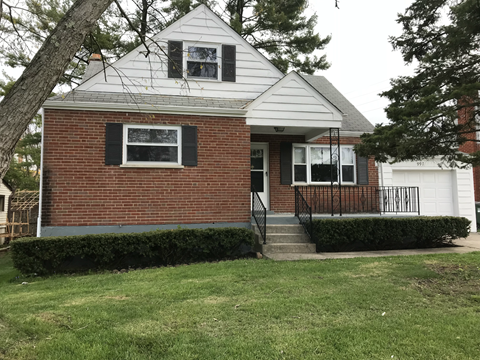 A small house with a white roof and a brick chimney.