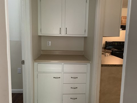A kitchen with white cabinets and drawers.