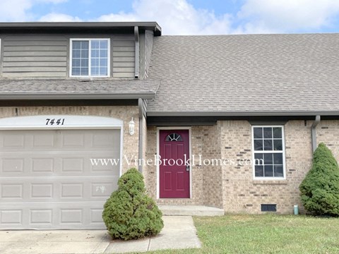 a house with a red door and a white garage door