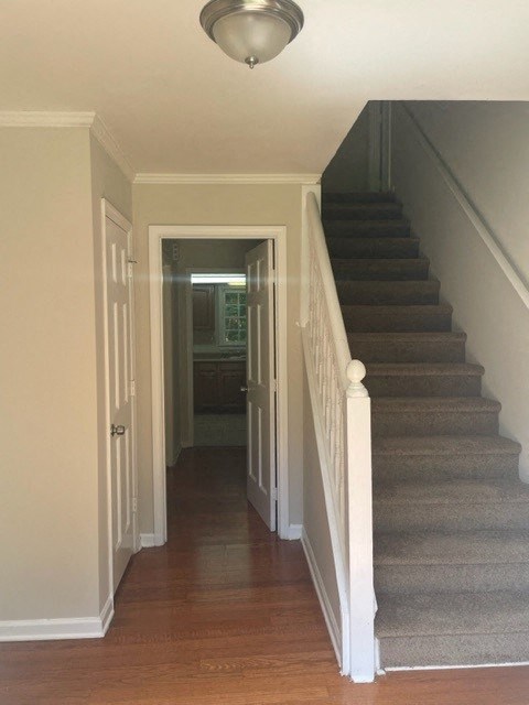 a hallway with stairs and a door to a room