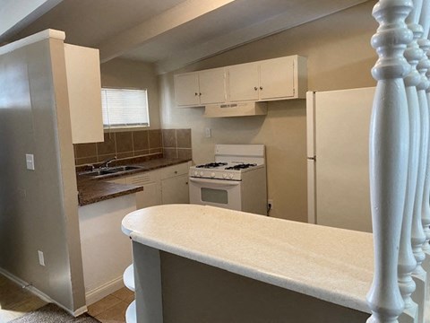 A kitchen with a stove top oven and a refrigerator.