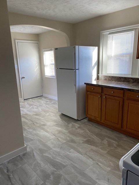 A kitchen with a white refrigerator and a white door.