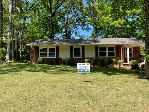 a house with a for sale sign in front of it