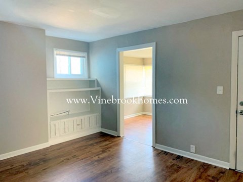 an empty living room with a door to a closet and a window